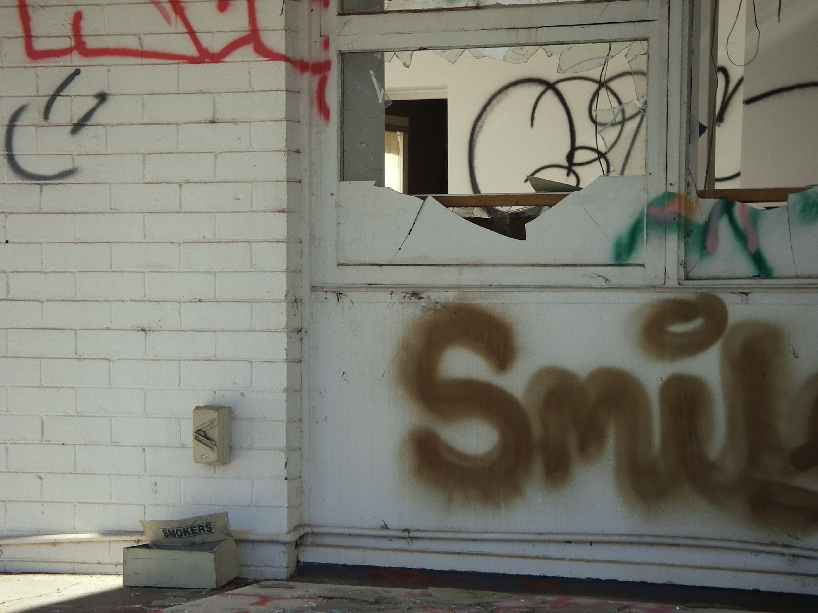a broken window with graffiti
